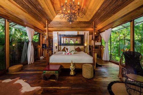 a bedroom with a bed and a chandelier at Ocho Artisan Bungalows in Tamarindo