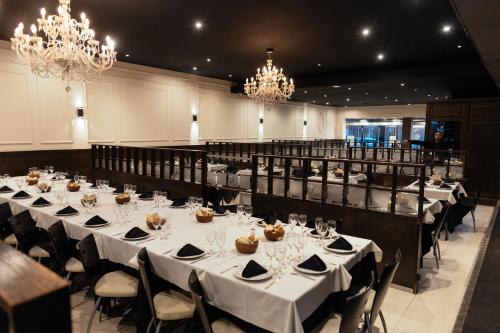 a banquet hall with white tables and chairs and chandeliers at Gran Hotel Miglierina in Mar del Plata