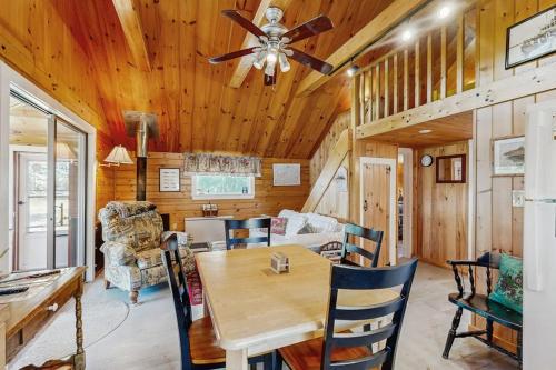 a dining room and living room with a wooden ceiling at Lakefront, cabin-inspired home with firepit, grill, & screened porch, Wifi in Greenville