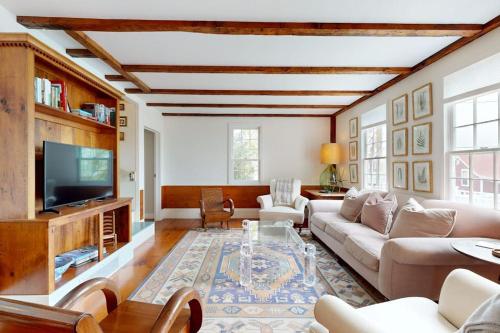 a living room with a couch and a tv at All-suite Boothbay Harbor home with deck, ocean views, and fireplaces in Boothbay Harbor
