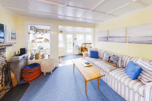 a living room with a couch and a table at Dog-friendly Fisher Hill home with patio and wood stove - walk to the harbor in Boothbay Harbor