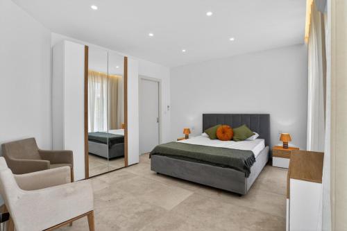 a bedroom with a bed and a mirror and a chair at Stylish Penthouse with private Pool andJacuzzi in Naxxar