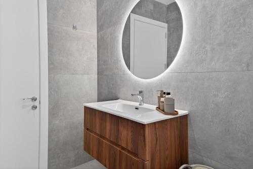 a bathroom with a sink and a mirror at Stylish Penthouse with private Pool andJacuzzi in Naxxar