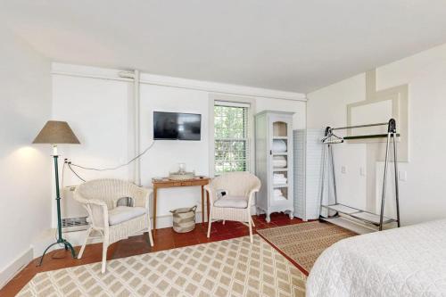 a bedroom with a bed and a desk and chairs at Downtown, ground floor studio near the ocean w/patio, outdoor dining area & more in Wiscasset