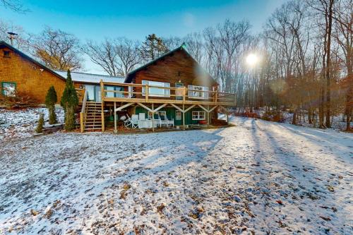 a log cabin in the winter with snow on the ground at Riverfront retreat with a furnished deck, washer/dryer & fast WiFi in Boothbay