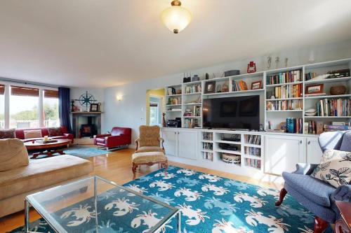 a living room with a couch and a tv at Expansive Modern Home w/ Ocean View, Gorgeous Garden & Dog-friendly in East Boothbay