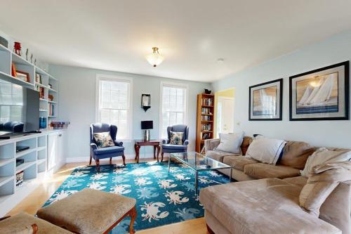 a living room with a couch and a table at Expansive Modern Home w/ Ocean View, Gorgeous Garden & Dog-friendly in East Boothbay