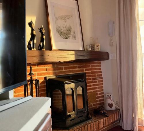 a living room with a brick fireplace with a picture at La Casita de Numancia in Garray
