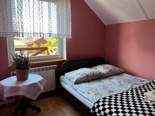 a small bedroom with a bed and a window at Chess Apartament in Augustów