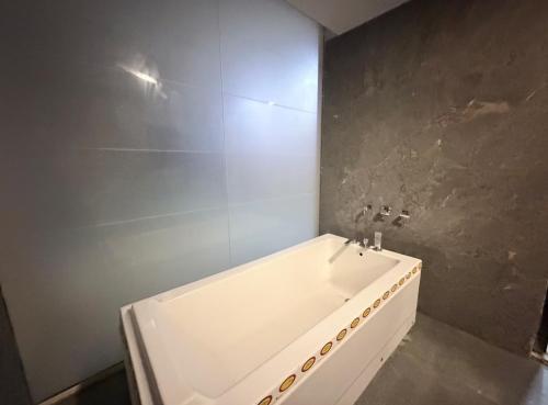 a bathroom with a white tub and a shower at The Lake view Timber House in Hyderabad