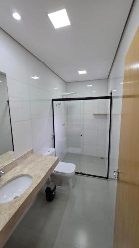 a bathroom with a toilet and a sink and a shower at Pousada Vila dos Anjos in Chapada dos Guimarães