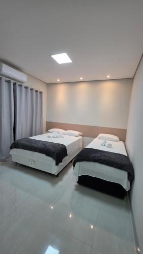 two beds sitting in a room with at Pousada Vila dos Anjos in Chapada dos Guimarães