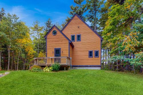 a large wooden house with a large yard at Appalachee Pond Waterfront Cottage | Decks, Sunroom, Dock with Kayaks & Canoe in Boothbay Harbor