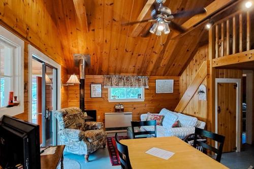 a living room with a couch and a table at Lakefront, cabin-inspired home with firepit, grill, & screened porch, Wifi in Greenville