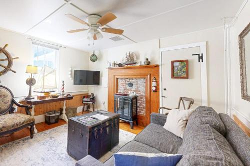 a living room with a couch and a fireplace at Historic Boothbay Harbor cottage with antique decor, washer/dryer & deck in Boothbay Harbor