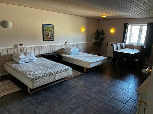 a room with two beds and a table and a chair at Eventyrborgen in Eskilstrup