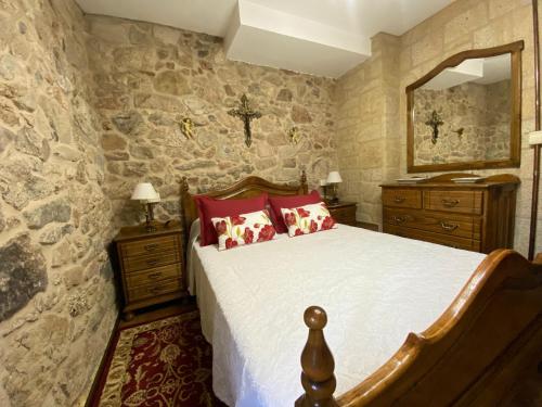 a bedroom with a bed and a stone wall at Casa Do Conde in Caldas de Reis