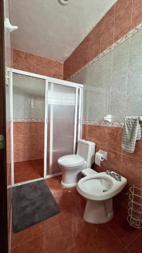a bathroom with a toilet and a sink at Casa Corazón de Boca, steps from the beach and restaurants in Boca del Río