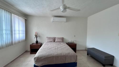 a bedroom with a bed and a ceiling fan at Casa Corazón de Boca, steps from the beach and restaurants in Boca del Río