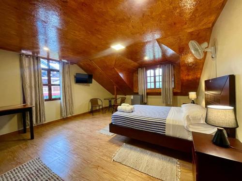 a bedroom with a bed and a wooden ceiling at MONTEVERDIA - Hotel & Resort in Pozuzo