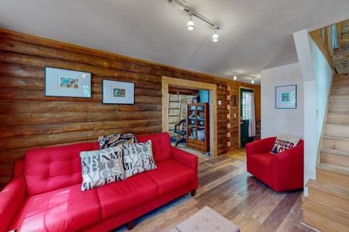 a living room with a red couch and two chairs at The Cottage - Peaceful 32-Acre Lakefront Getaway - Canoe, Firepit & Big Deck in Franklin