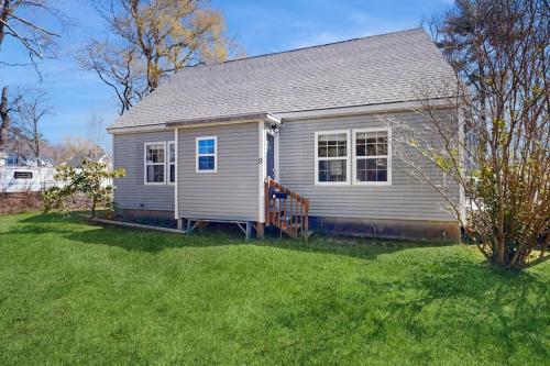 a small house in a yard with green grass at Dog-friendly home with deck, pool table, & firepit - walk to downtown Boothbay in Boothbay Harbor