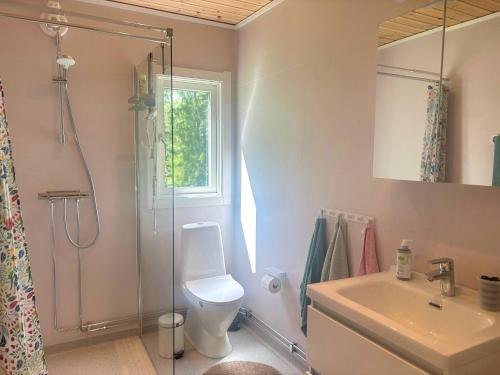a bathroom with a toilet and a shower and a sink at Stuga Haget in Bengtsfors