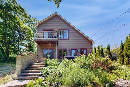 a house with a staircase in front of it at Dog-friendly home with high-speed WiFi, washer/dryer, & private dock in Cundys Harbor