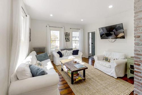 a living room with two white couches and a table at Coastal home with new, full kitchen, walkable downtown location in Boothbay Harbor