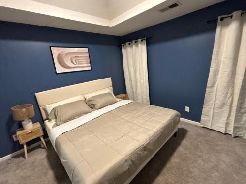 a bedroom with a large bed with blue walls at Elegant luxurious paradise in Decatur