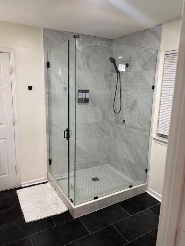 a shower with a glass door in a bathroom at Elegant luxurious paradise in Decatur