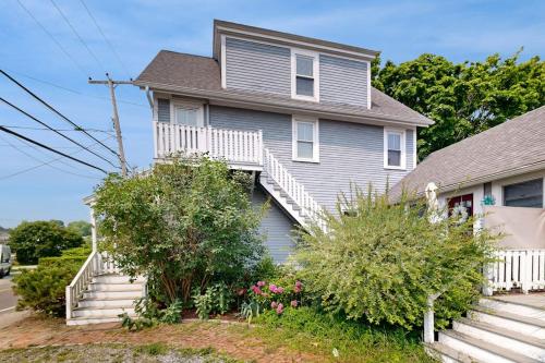 a house with stairs and flowers in front of it at Charming, historic cottage with modern upgrades - stroll to dining & attractions in Boothbay Harbor