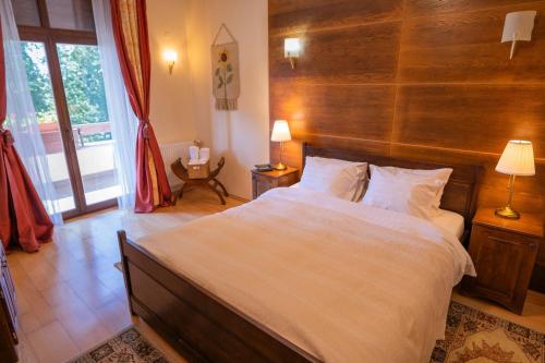 a bedroom with a large bed with a wooden headboard at Transylvanian Villa in Predeal