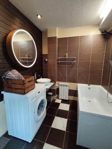a bathroom with a washing machine and a tub at Turu 6, Quiet Central Apartment in Haapsalu