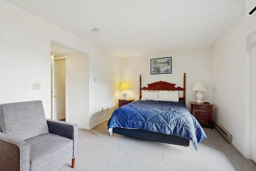 a bedroom with a bed and a chair at Newly-furnished condo with loft, fast WiFi, partial AC, grills & yard access in Bar Harbor
