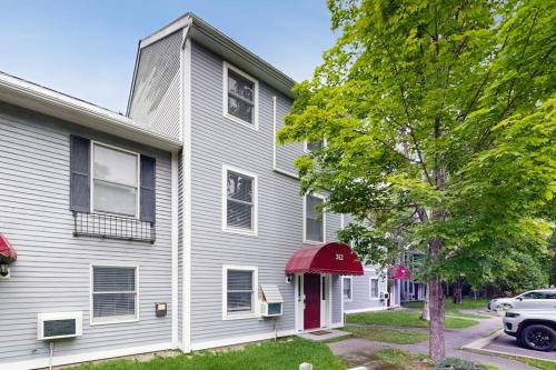 a gray house with a red door at Townhome w/ Bonus Loft, High-Speed WiFi, Partial AC & Full Kitchen in Bar Harbor