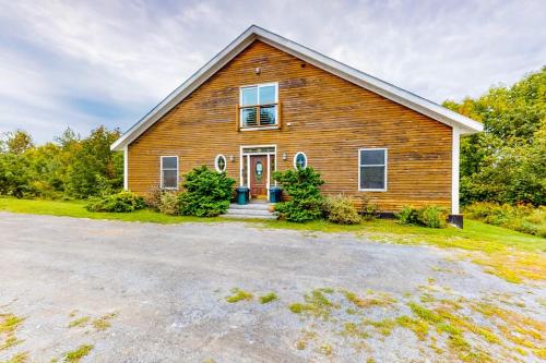 a large wooden house with a driveway at Lakefront home with outdoor firepit & private dock - near downtown in Greenville