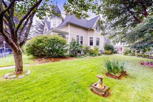 a house with a yard with a birdbath in the grass at Dog-friendly historical home with recent updates, porch & prime in-town location in Rockland