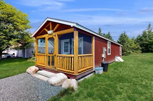 a large wooden cabin in a field of grass at Cozy Cabin with Ocean and Mountain Views, Free Internet in Sullivan
