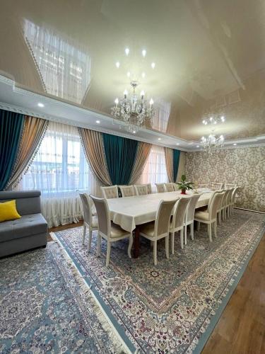 a dining room with a long table and chairs at Zirek House in Bishkek