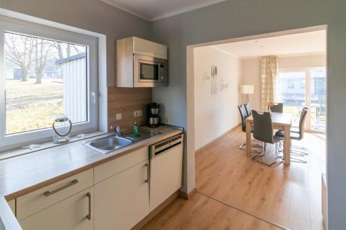 a kitchen with a sink and a dining room with a table at Melanie in Lenz