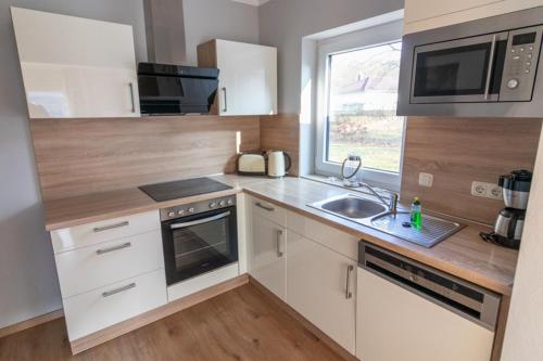 a kitchen with white cabinets and a sink and a window at Melanie in Lenz