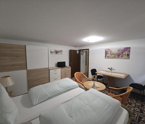 a bedroom with a bed and a desk and a table at Wider Apartment UG mit Tageslicht in Gottmadingen