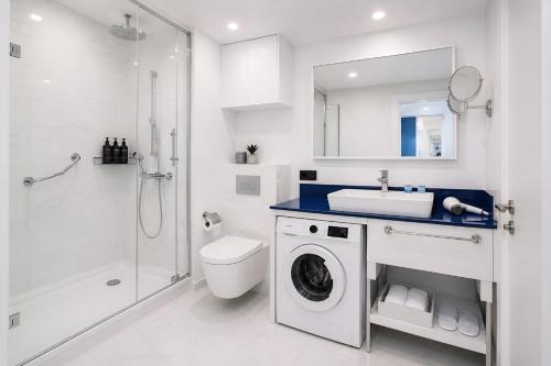 a bathroom with a toilet sink and a washing machine at Royal Sea View Batumi in Batumi