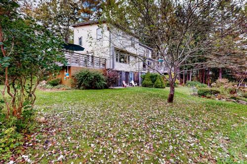 a large house with a tree in the yard at Dog-friendly ocean-view duplex with wood stoves, decks, grills, kitchens, ACs in Southwest Harbor