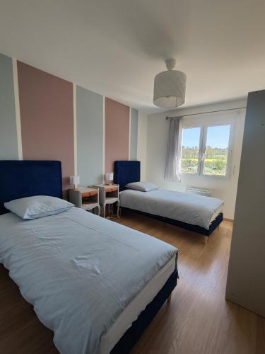 a bedroom with two beds and a window at Villa Melloco in Varilhes