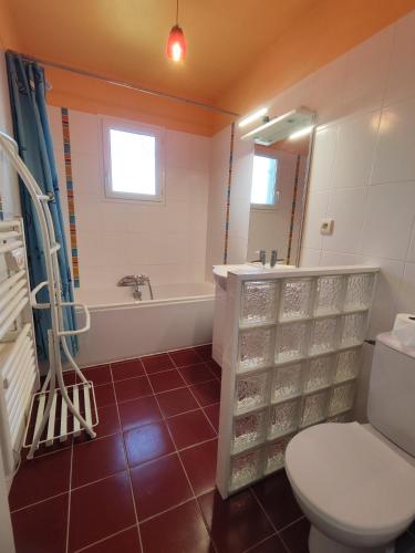 a bathroom with a toilet and a tub and a sink at Villa Melloco in Varilhes