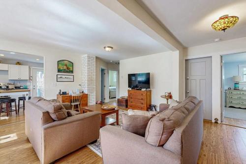 a living room with two couches and a kitchen at Coastal bungalow with large yard, beautiful kitchen, & great location in Boothbay Harbor
