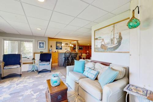 a living room with a couch and a table at Oceanfront home with dock, beautiful deck & firepit - steps to the beach in Harpswell Center