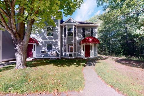 a gray house with a red door and a tree at Bay View Dog-Friendly Townhouse w/Porch, Gas Grill, Washer/Dryer, Partial A/C in Bar Harbor